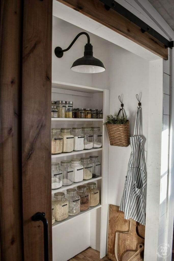 Smart pantry storage with clear glass jars and wooden shelves.