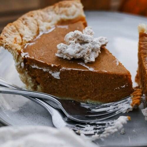 slice of homemade pumpkin pie made with maple syrup on a plate.