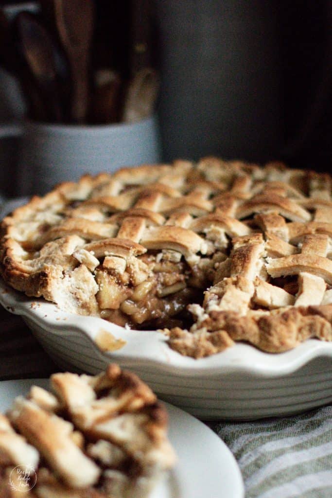 An apple pie in an ironstone type dish that is made with maple syrup