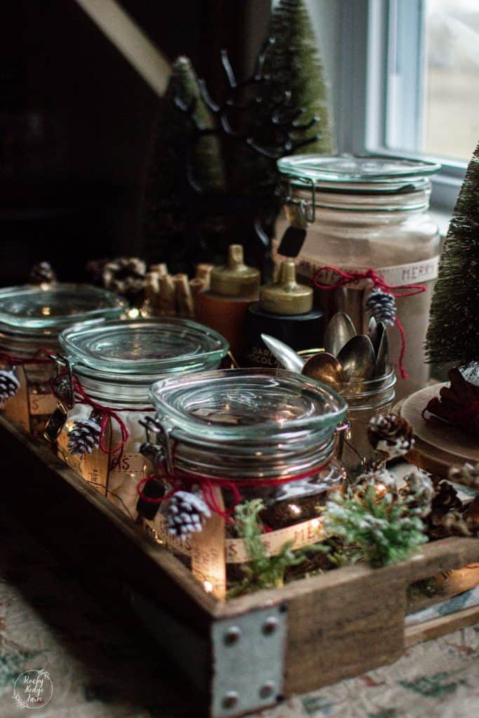 Wooden tray decorated with jars and Christmas decor for a hot chocolate bar