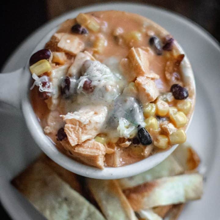 A bowl of creamy southwest chicken soup topped with sourcream and cheese