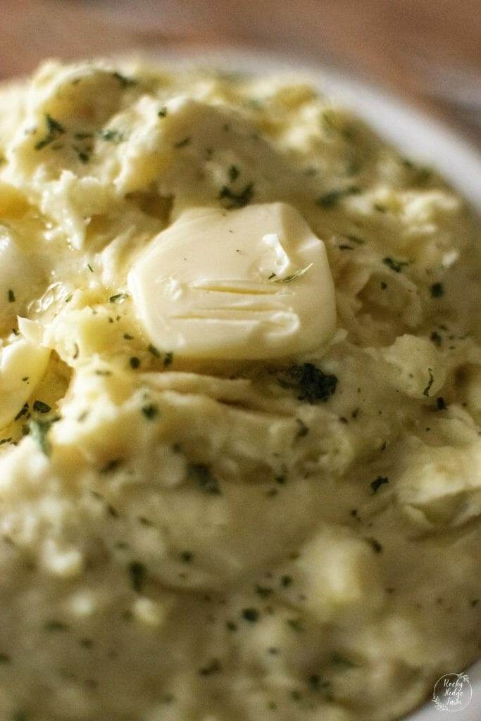 Butter slice melting on top of fully loaded mashed potatoes