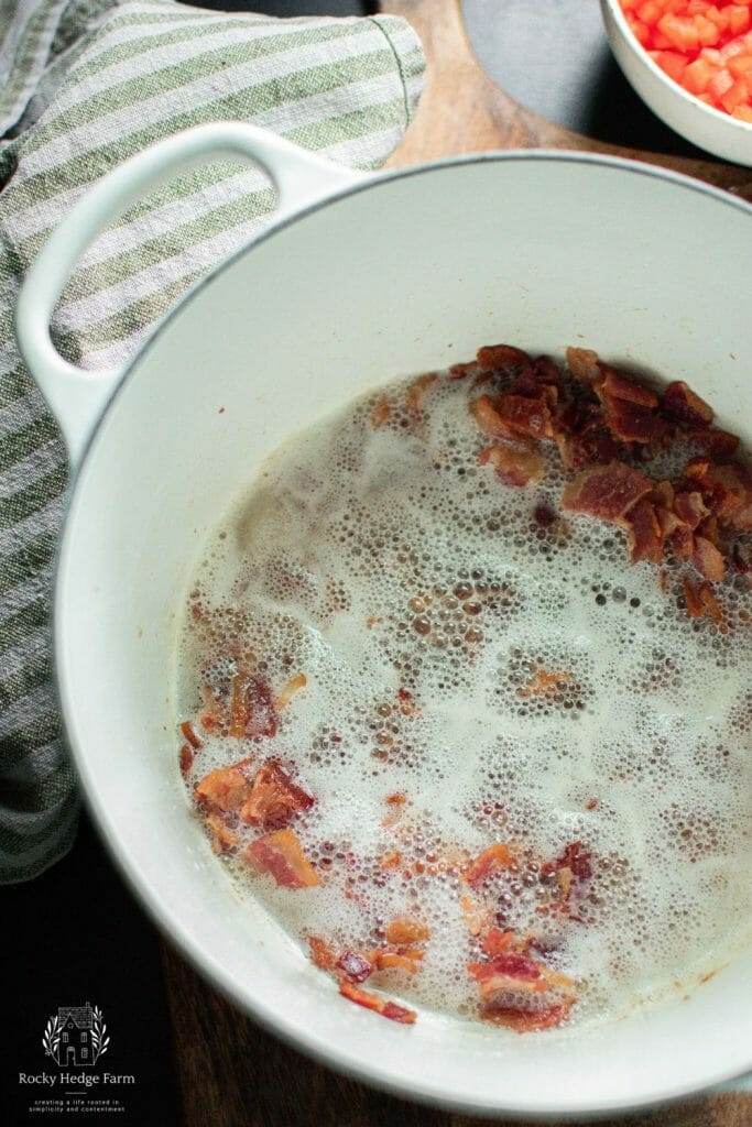 cooked bacon in a white cast iron dutch oven