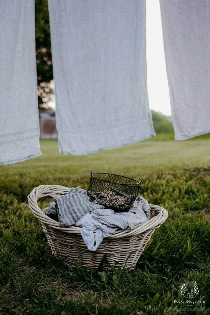 a basket full of laundry with towels drying on the clothesline in the background