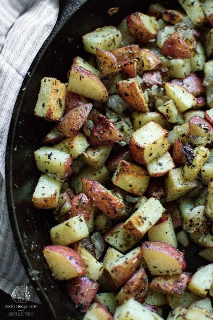 Close-up of crispy roasted potatoes and tender onions in a cast iron skillet