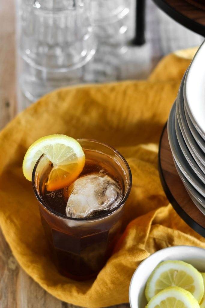 A refreshing glass pitcher of iced tea on a table.