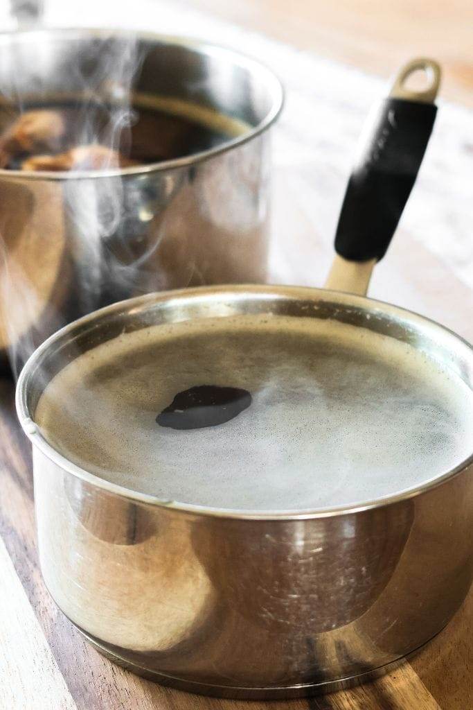 A pot of simple syrup for sweet tea on a wooden table.