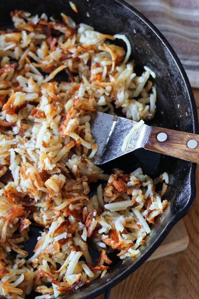 Cooked hash browns in a cast iron skillet