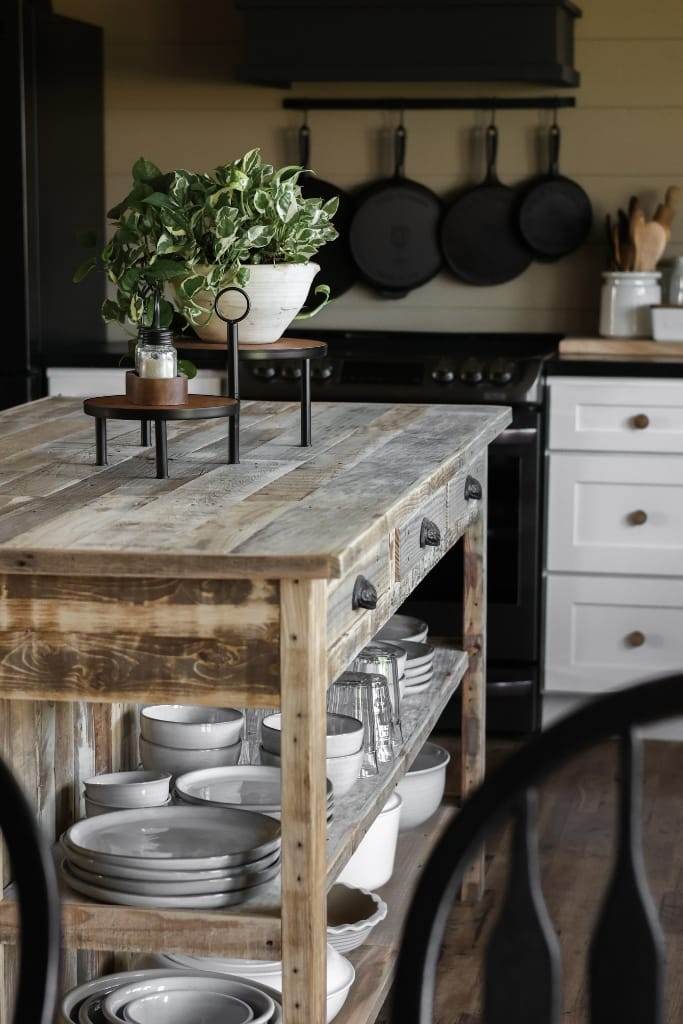 rustic kitchen island crafted from reclaimed wood. The island boasts a unique character with its natural wood grain and imperfections. It serves as a multifunctional workspace.