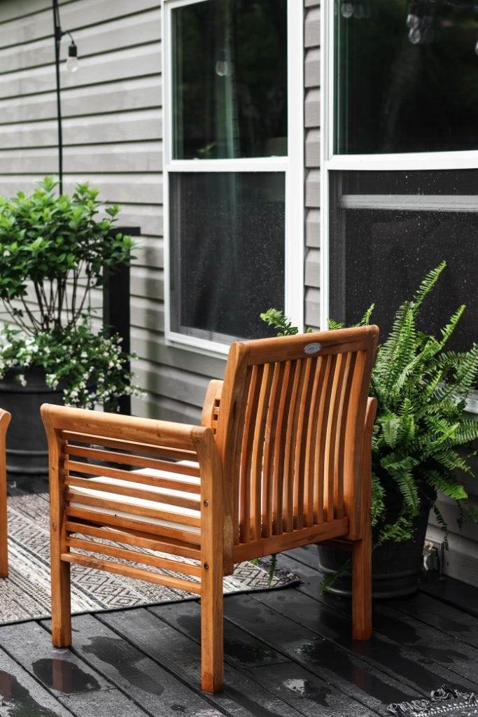 Black stain and cozy furniture transform a manufactured home porch into a stylish haven.