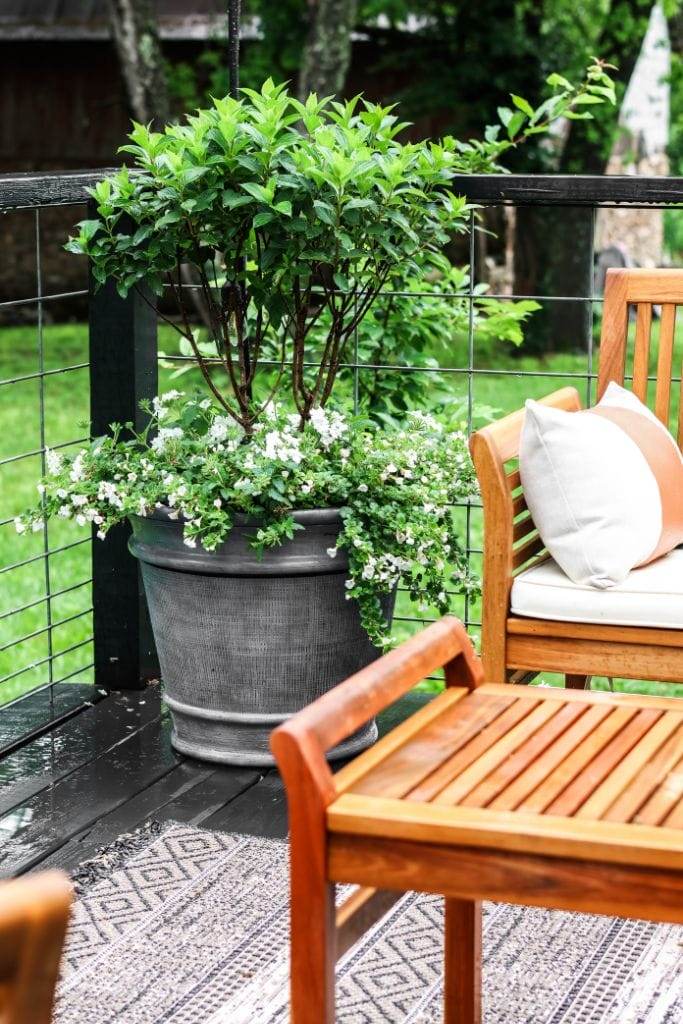 Outdoor rug, string lights, and planters add personality to a manufactured home porch.