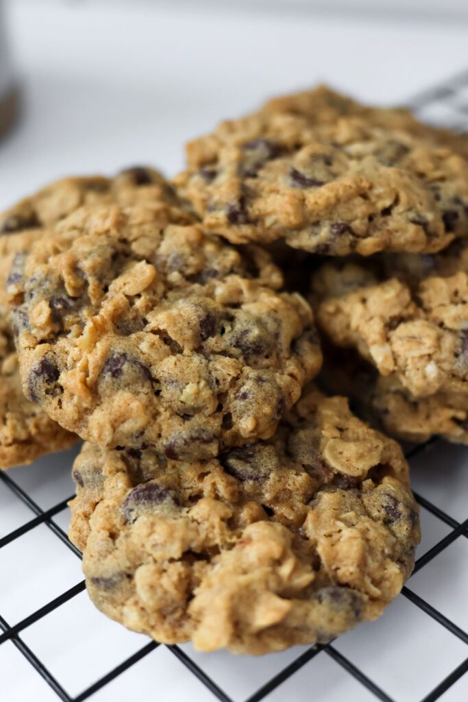 A batch of freshly baked no-chill oatmeal chocolate chip cookies cooling on a wire rack.