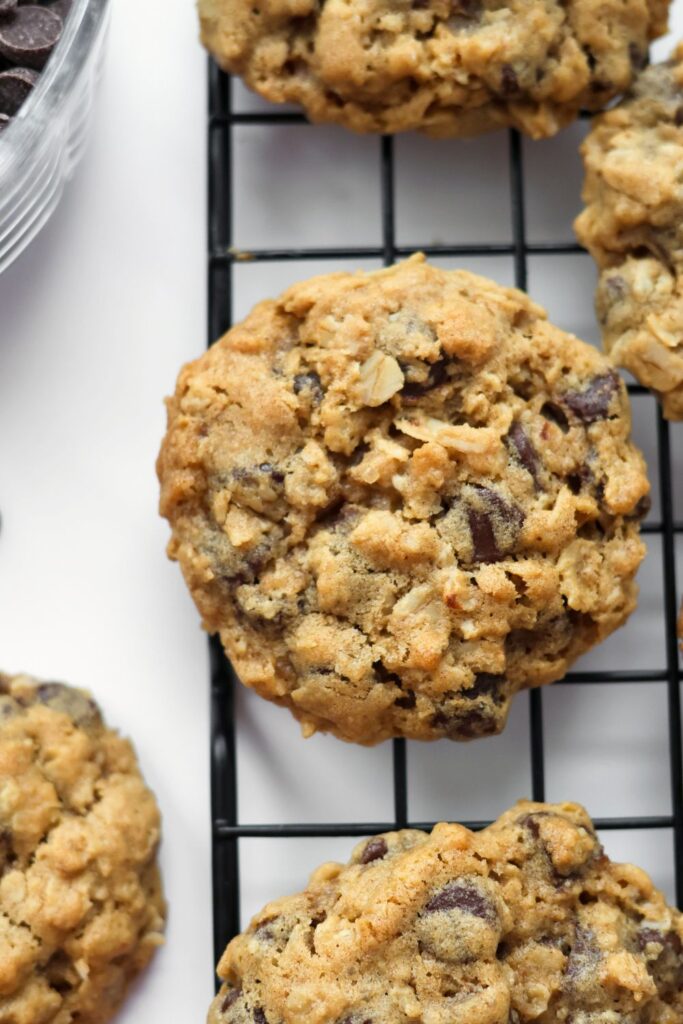 A close-up of golden-brown no-chill oatmeal chocolate chip cookies showing melted chocolate chips