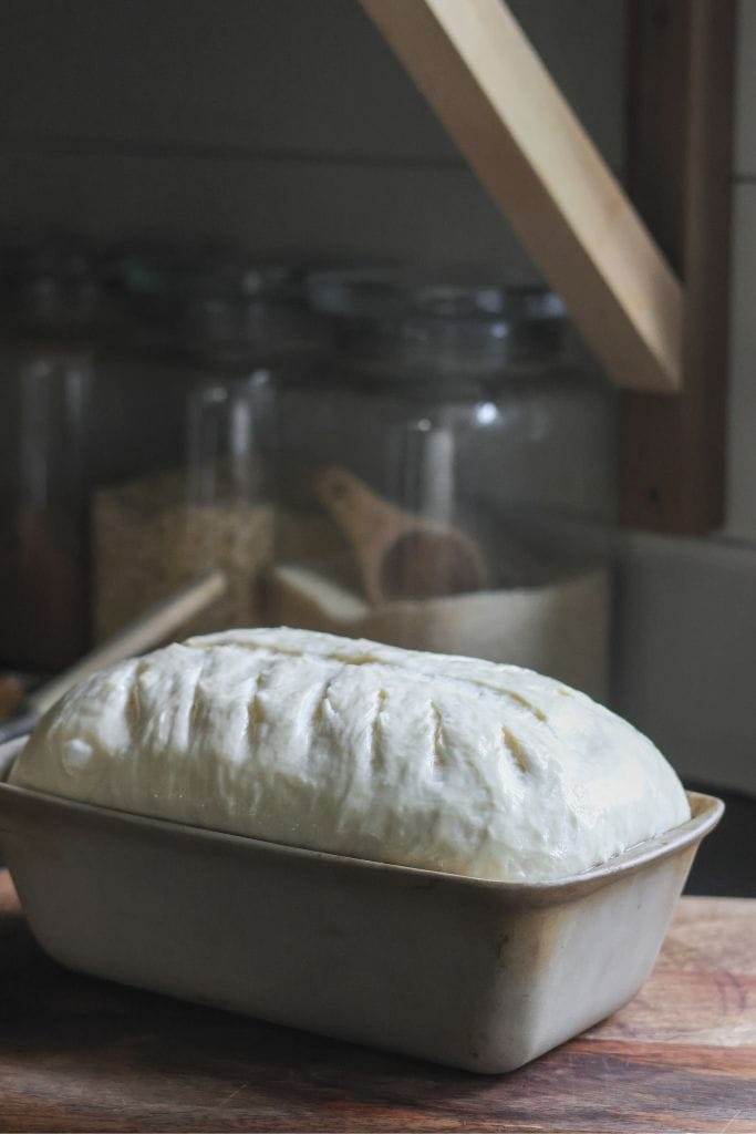 upclose photo of bread in a loaf pan that is ready to baked