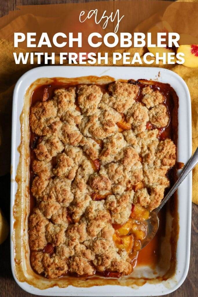 White pan filled with homemade peach cobbler with fresh peaches