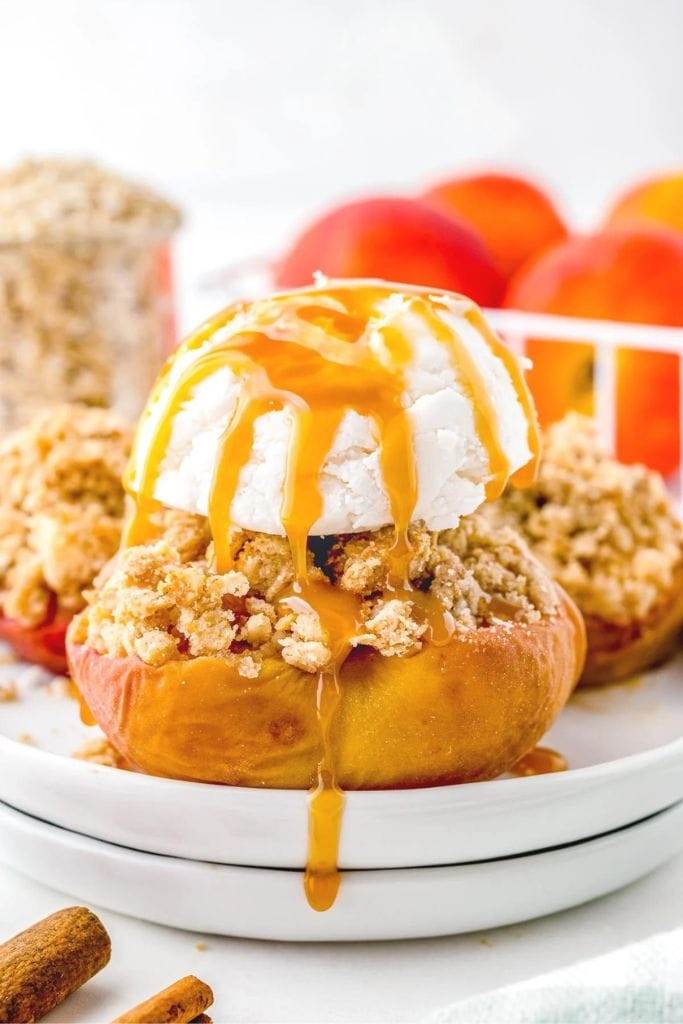 a baked peach with oat topping