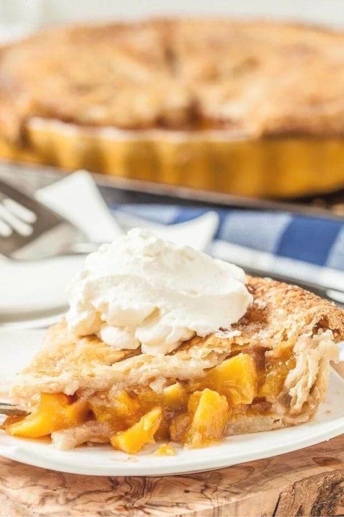 a slice of Fresh Peach Pie with Flaky Butter Crust with vanilla ice cream