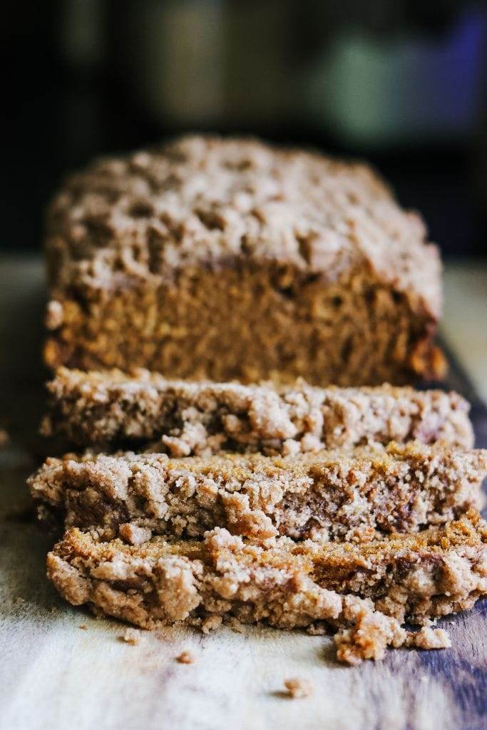 Stacked slices of freshly baked pumpkin bread with a crunchy streusel topping, ready to be served.