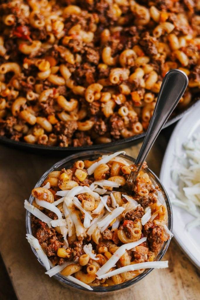 a glass bowl filled with southwest ground beef skillet recipe and topped with cheese