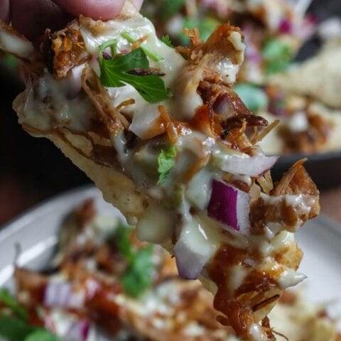 a close up of bbq nachos on a tortilla chip