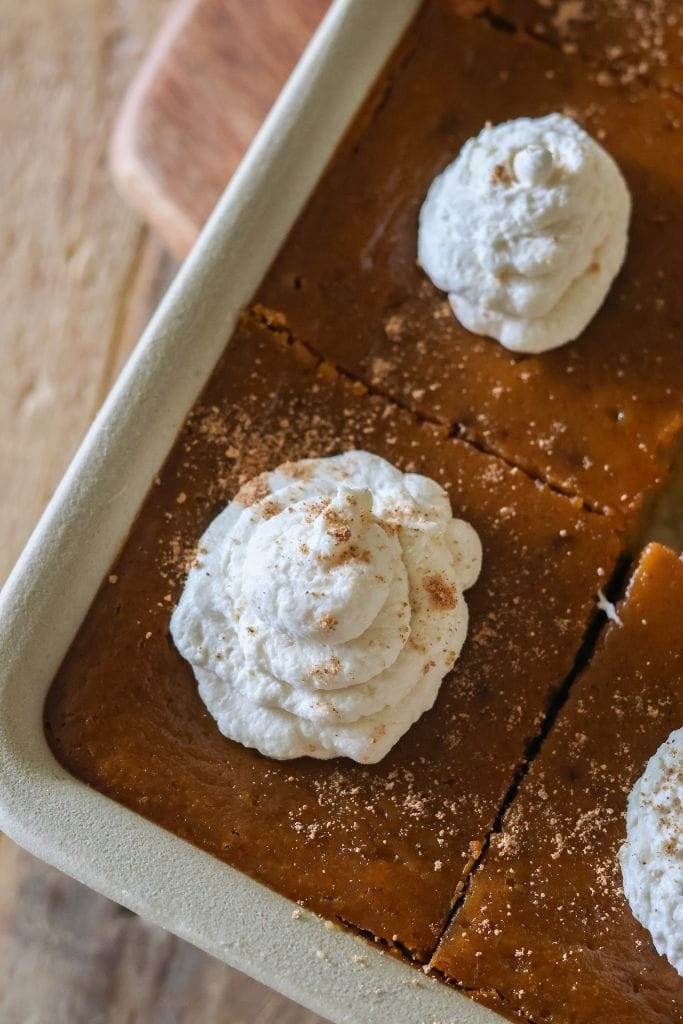 Sliced pumpkin pie bars with whipped cream dollops