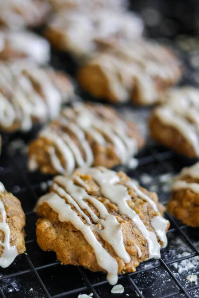 A close-up of soft pumpkin oatmeal cookies drizzled with a cinnamon maple glaze