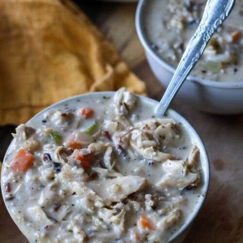 Creamy chicken and wild rice soup served in white ceramic bowl