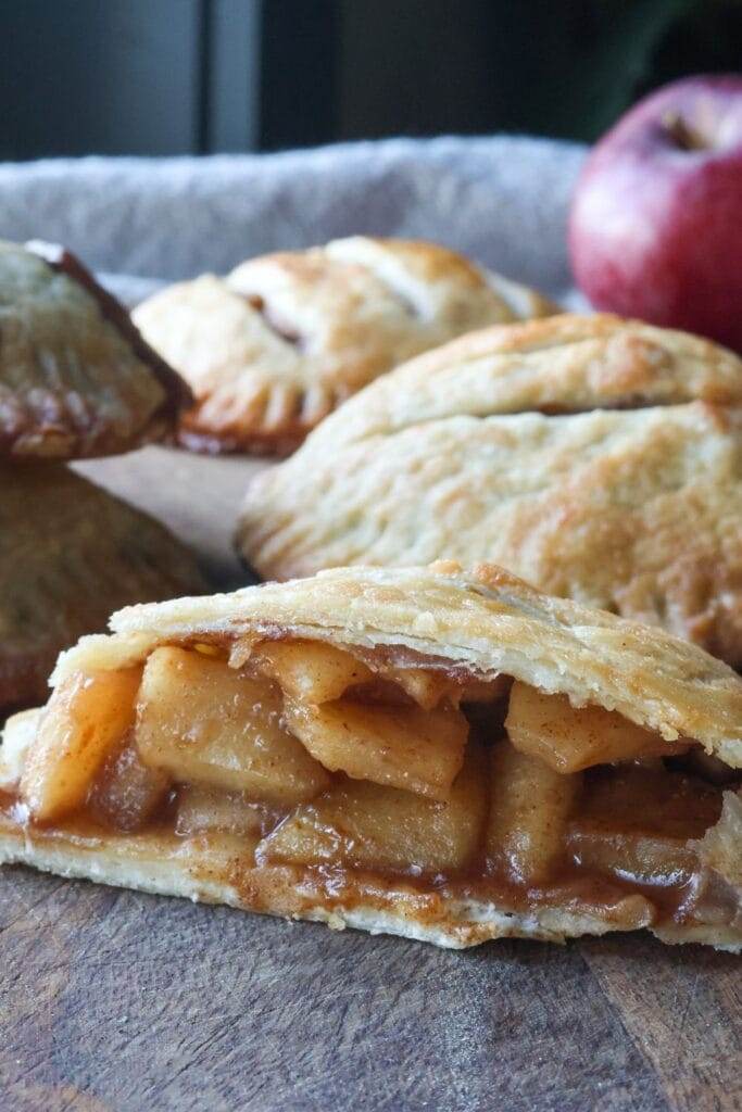 Apple hand pie sliced in half to reveal the warm, spiced apple filling nestled inside the flaky crust.