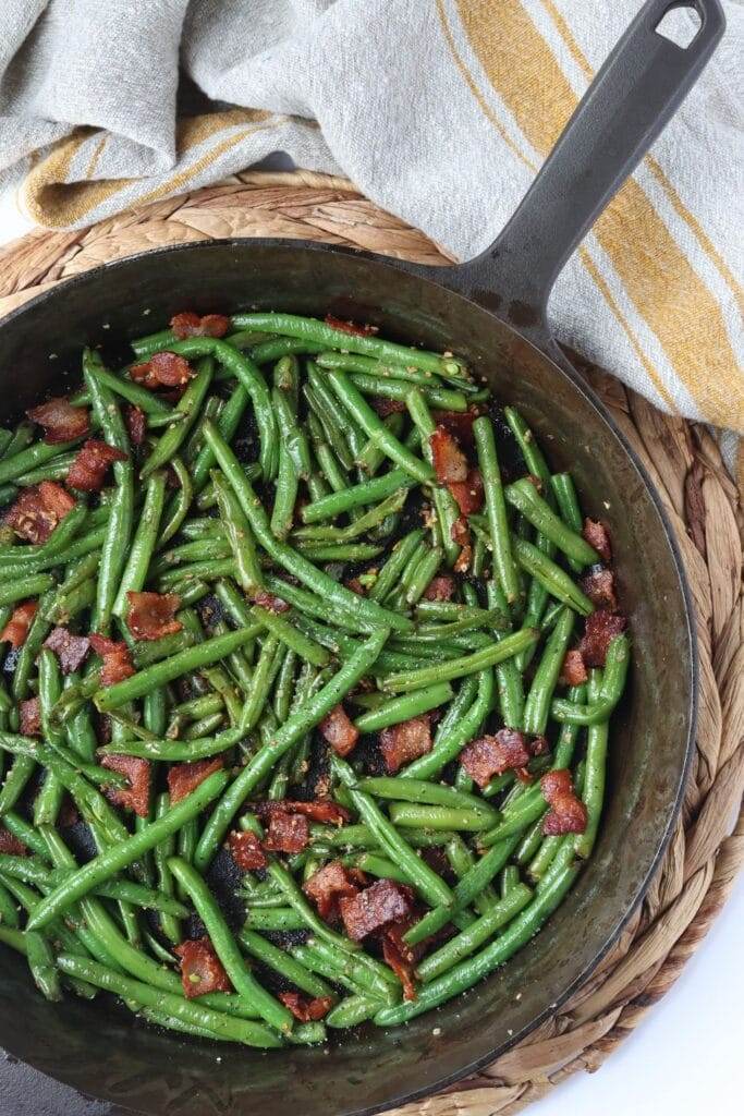 Tender green beans cooked with garlic and onion, served in a cast iron skillet.