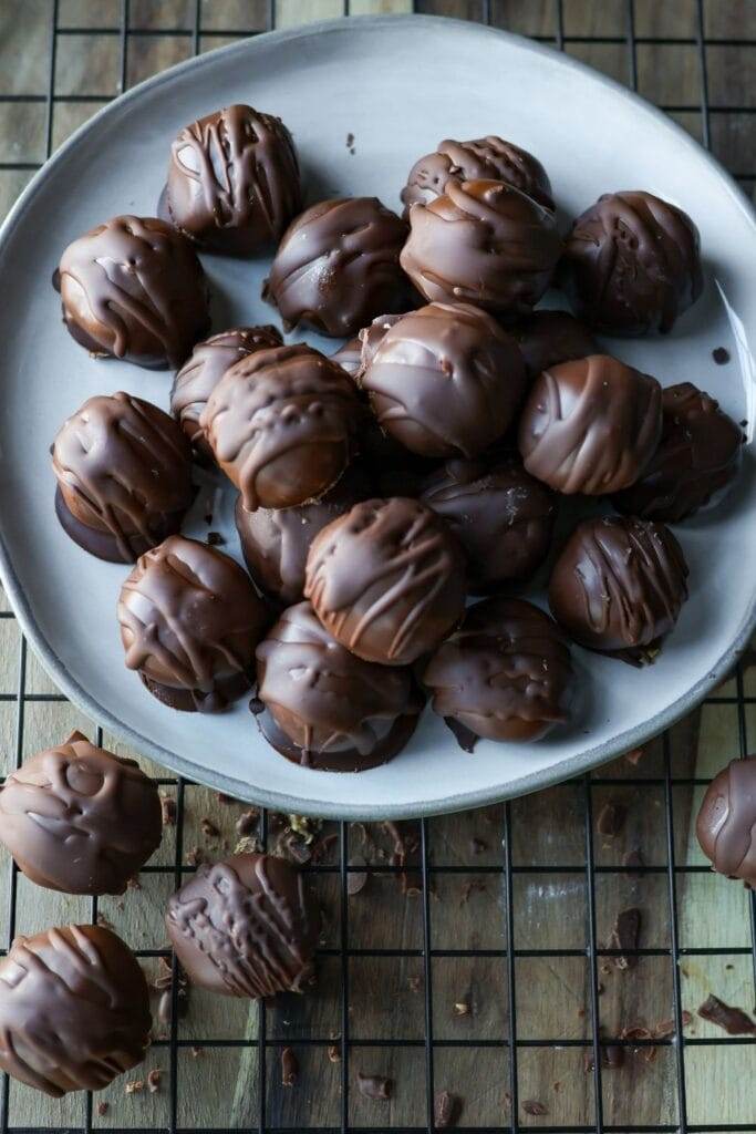 Close-up of peanut butter balls with a smooth chocolate coating.