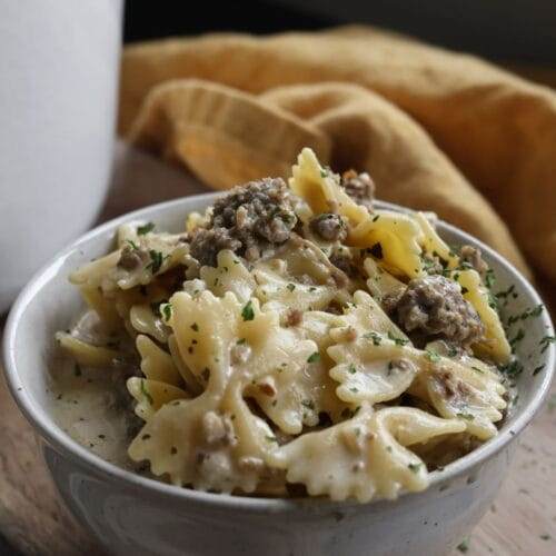 A hearty bowl of Italian sausage soup with a creamy parmesan broth, topped with grated parmesan