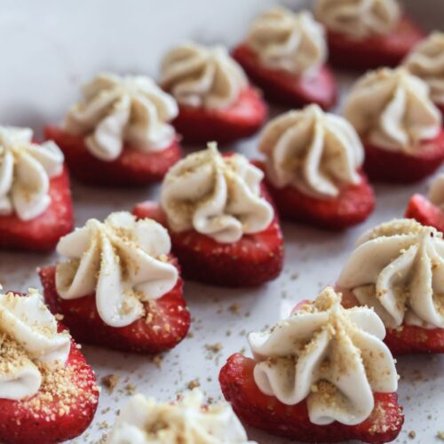 Close-up of deviled strawberries filled with a smooth cheesecake mixture, topped with graham cracker crumbs