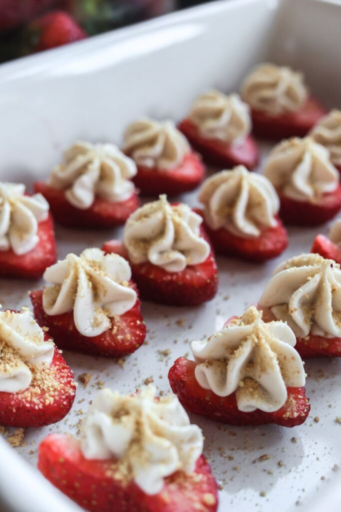 Close-up of deviled strawberries filled with a smooth cheesecake mixture, topped with graham cracker crumbs