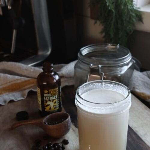 Combining heavy cream, half-and-half, maple syrup, and vanilla extract in a pint jar to make homemade coffee creamer.