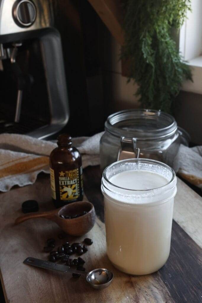 Combining heavy cream, half-and-half, maple syrup, and vanilla extract in a pint jar to make homemade coffee creamer.