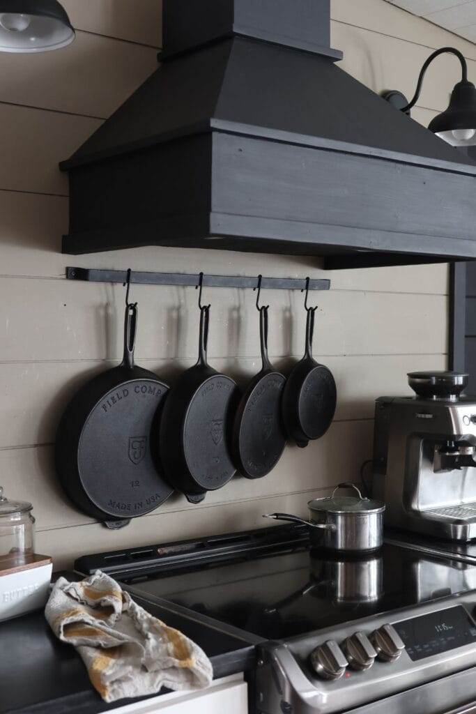 A row of cast iron skillets hanging above the stove.