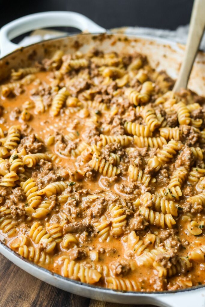 Cheesy ground beef pasta served in a cast iron skillet, showcasing the rich, creamy sauce and hearty ingredients in a single-pan meal.