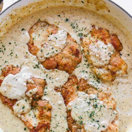 an overhead view of a pan full of creamy garlic chicken