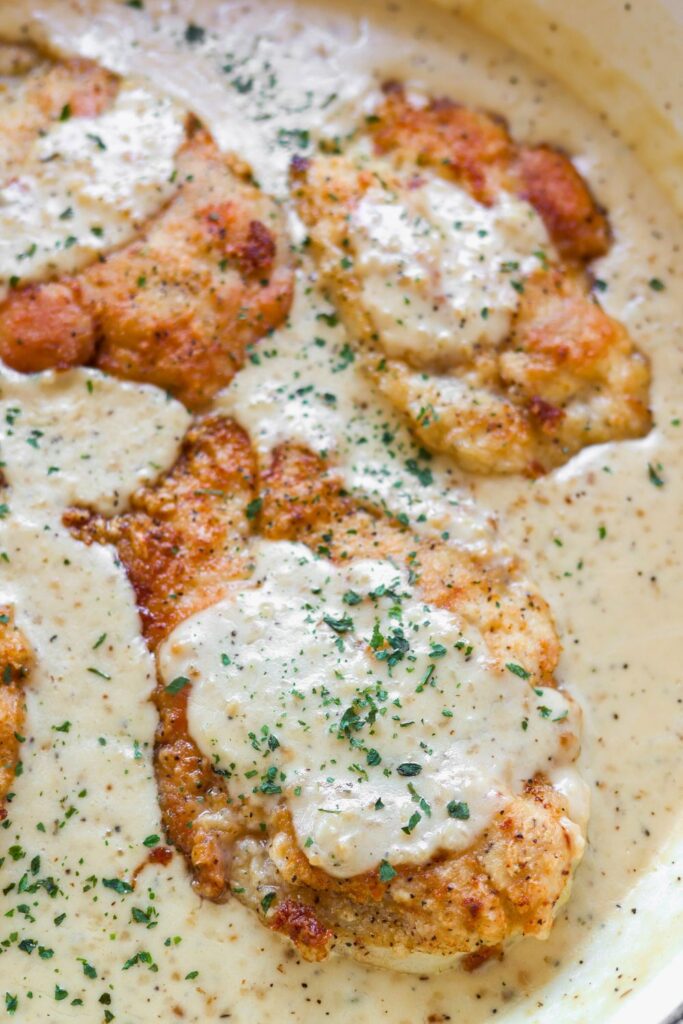 an overhead view of creamy garlic chicken with the sauce drizzled over the top.