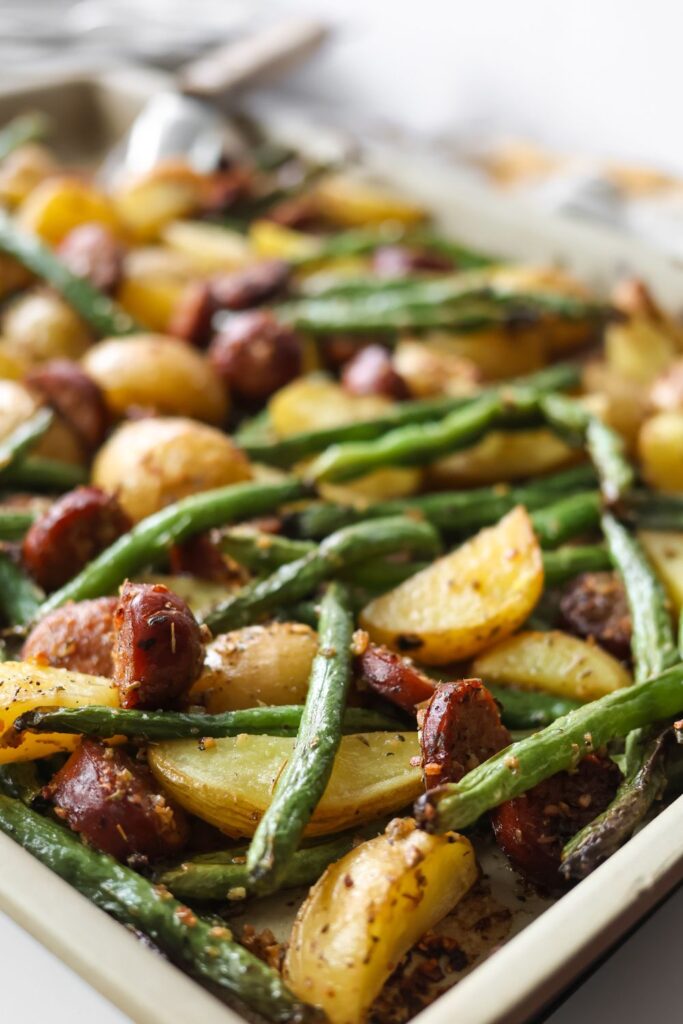 Sheet pan meal with roasted sausage, crispy potatoes, and green beans fresh from the oven