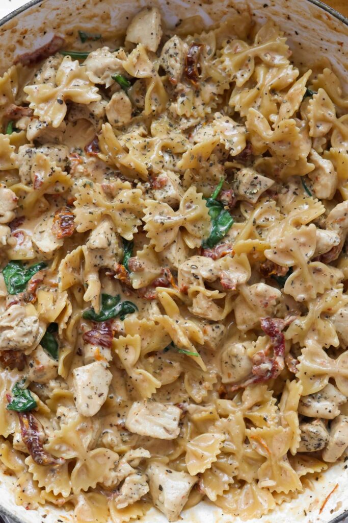 An overhead shot of a skillet filled with creamy Tuscan chicken pasta