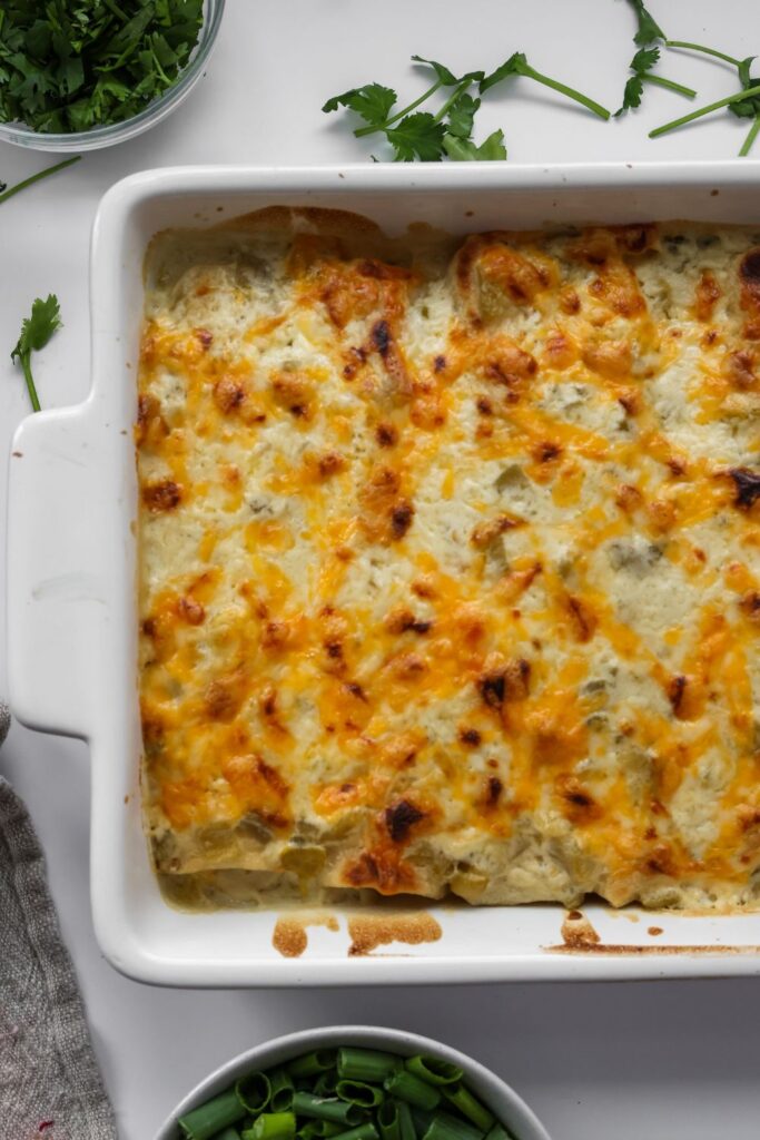 Close-up of cheesy white chicken enchiladas with creamy sauce 