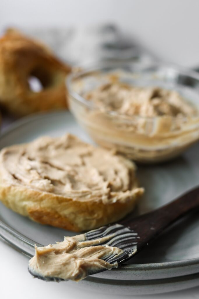 a wooden knife with cinnamon cream cheese spread on the end of it