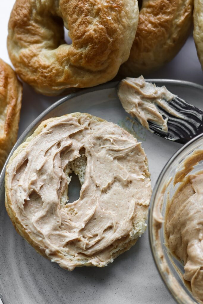 An overhead shot of a bagel covered with brown sugar cinnamon cream cheese.