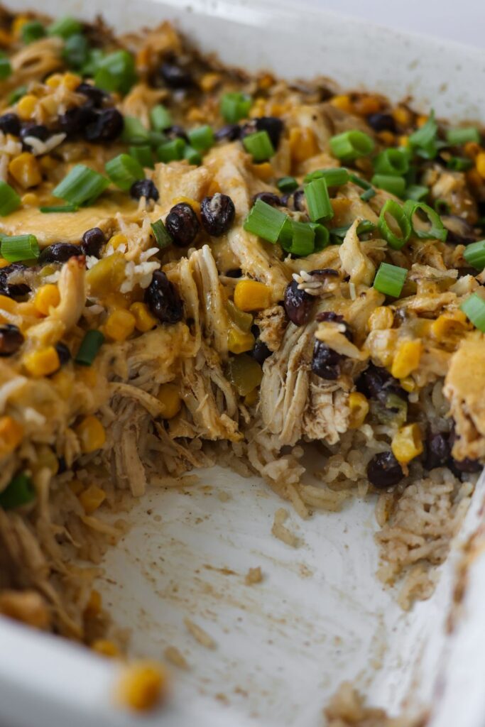 Chicken Burrito Casserole fresh out of the oven in a 9x13 baking dish, with layers of rice, chicken, and cheese.