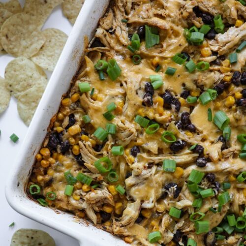 Chicken Burrito Casserole fresh out of the oven in a 9x13 baking dish, with layers of rice, chicken, and cheese.