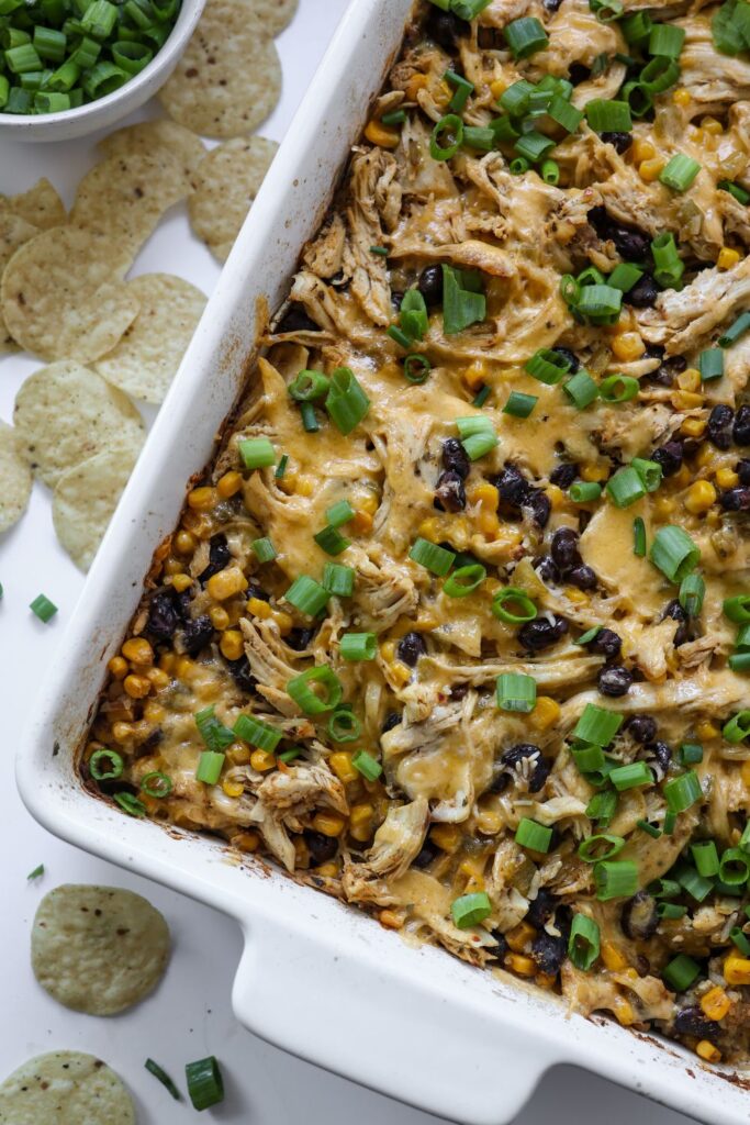 Chicken Burrito Casserole fresh out of the oven in a 9x13 baking dish, with layers of rice, chicken, and cheese.