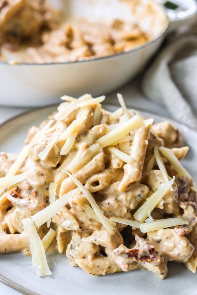 Marry Me Chicken Pasta on a white plate ready to serve, with a creamy sun-dried tomato sauce